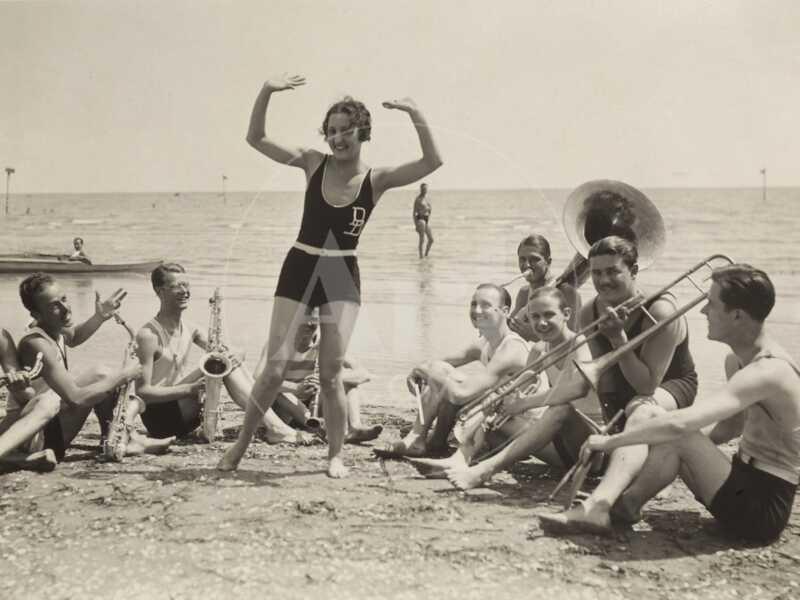 A Young Woman, Surrounded by Musicians, Dances on a Beach of the Lido of Venice