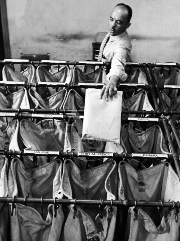 Man Sorting Mail in the State Dept. Building, Each Bag is Labeled with Foreign City Destination - Premium Photographic Print