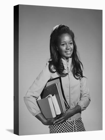 1960s AFRICAN AMERICAN TEEN GIRL CARRYING SCHOOL BOOKS-Panoramic Images-Premier Image Canvas