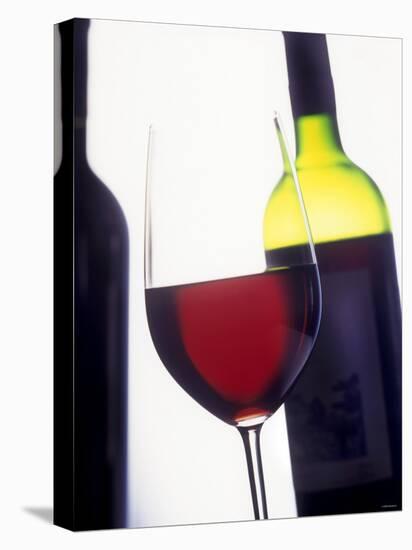 A Glass of Red Wine with a Bottle in the Background-Armin Faber-Premier Image Canvas