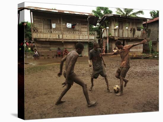 A Group of Panamanian Youths Slide Through the Mud During a Pick-Up Game of Soccer-null-Premier Image Canvas