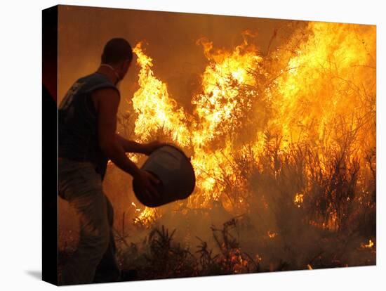 A Local Resident Throws a Bucket of Water on a Forest Fire-null-Premier Image Canvas