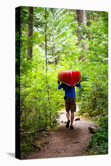 A Man Carries A Canoe Along The Portage Trail To The Priest Lake Thoroughfare-Ben Herndon-Premier Image Canvas