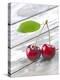 A Pair of Cherries with a Leaf on a Wooden Table-Jürgen Klemme-Premier Image Canvas