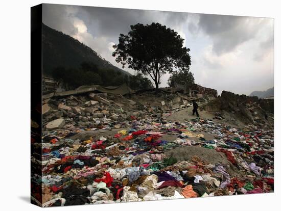 A Pakistani Refugee Walks Past Clothing Left Strewn on the Ground-null-Premier Image Canvas