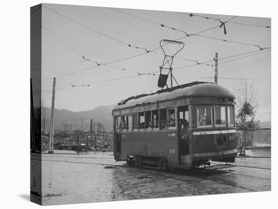 A Passenger-Filled Streetcar Traveling Through a Bomb-Damaged City-null-Premier Image Canvas
