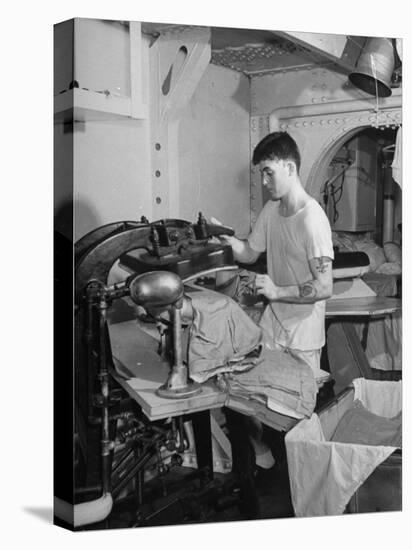 A Sailor Pressing Uniform Trousers in the Tailor Shop of a US Navy Cruiser-null-Premier Image Canvas