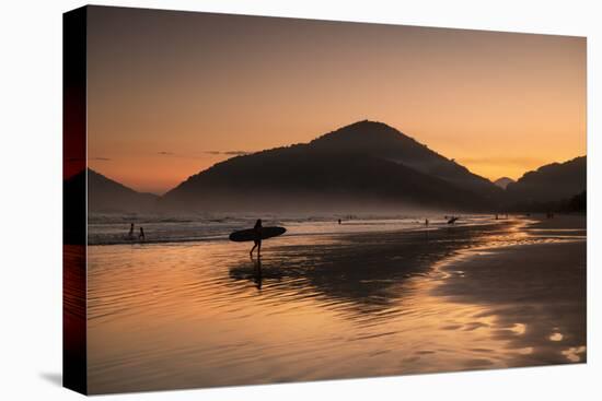 A Surfer Makes His Way Out of the Water at Sunset on Praia Do Itamambuca in Brazil-Alex Saberi-Premier Image Canvas