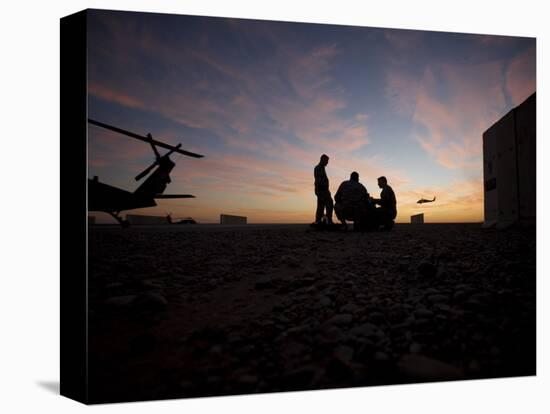 A UH-60 Black Hawk Crew Carry Out a Mission Brief at Sunset-null-Premier Image Canvas