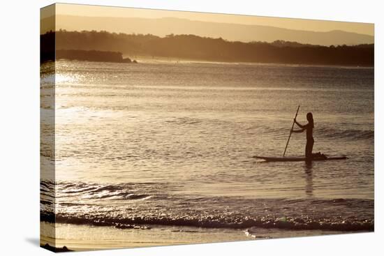 A Woman on a Stand-Up Paddleboard Heads Towards Main Beach, Noosa, at Sunset-William Gray-Premier Image Canvas