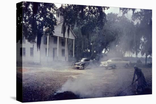 A Woman Rakes and Burns Brush in Front of a Church on Edisto Island, South Carolina, 1956-Walter Sanders-Premier Image Canvas