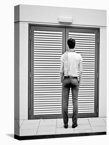 A Young Man Standing in the Street Looking at a Pair of Doors-India Hobson-Premier Image Canvas