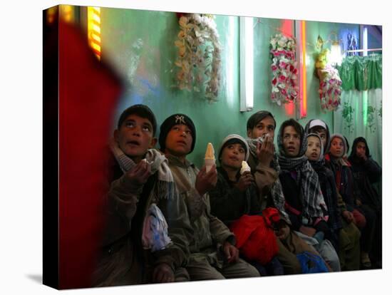 Afghan Boys Watch a Movie on a Television, Unseen, as They Eat Ice Cream at an Ice Cream Shop-Rodrigo Abd-Premier Image Canvas