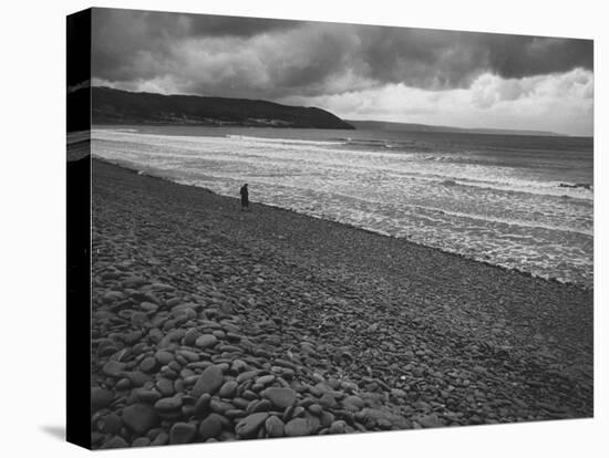 Along British Coastline, Woman Walking on Pebbled Shore-Nat Farbman-Premier Image Canvas