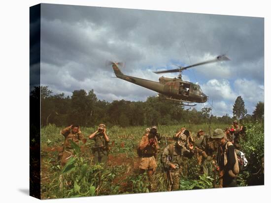 American UH1 Huey Helicopter Lifting Off as Personnel on the Ground Protect Themselves-Larry Burrows-Premier Image Canvas