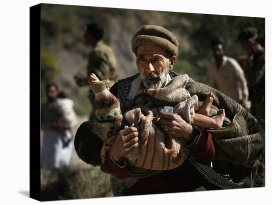 An Elderly Pakistani Earthquake Survivor Rushes Towards a Helicopter Carrying a Child in His Arms-null-Premier Image Canvas