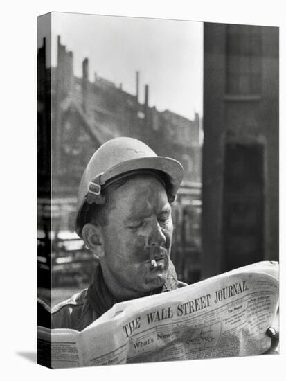 An Electrician Reads 'The Wall Street Journal' to Check His Stock Market Investments-null-Stretched Canvas