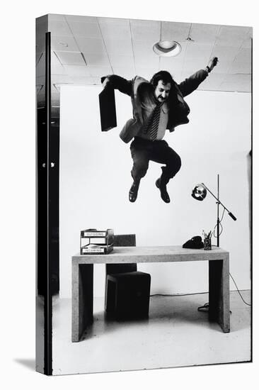 Architect and Designer Frank Gehry Jumping on a Desk in His Line of Cardboard Furniture-Ralph Morse-Premier Image Canvas