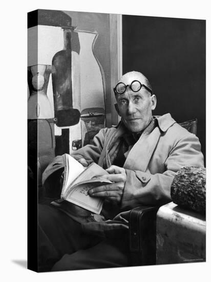 Architect Le Corbusier Sitting in Chair and Holding Book in Hands-Nina Leen-Premier Image Canvas
