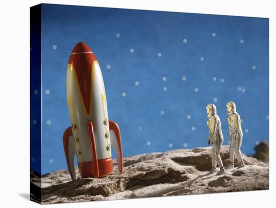 Astronaut Figurines Standing Beside Toy Rocket-null-Premier Image Canvas