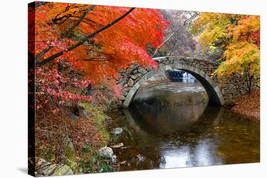 Autumn color and old stone arched bridge at Namsangol traditional folk village, Seoul, South Korea-null-Stretched Canvas