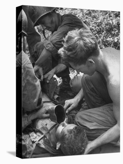 Badly Wounded Medic Being Given Water While Soldier in Background Cuts Clothing from His Wounds-null-Premier Image Canvas