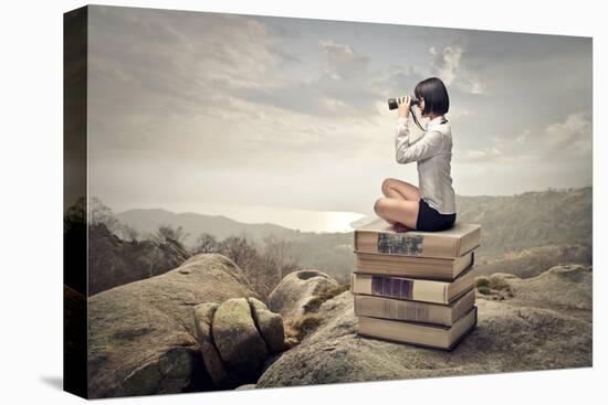 Beautiful Woman Sitting On A Pile Of Old Books Watching With Binoculars-olly2-Stretched Canvas