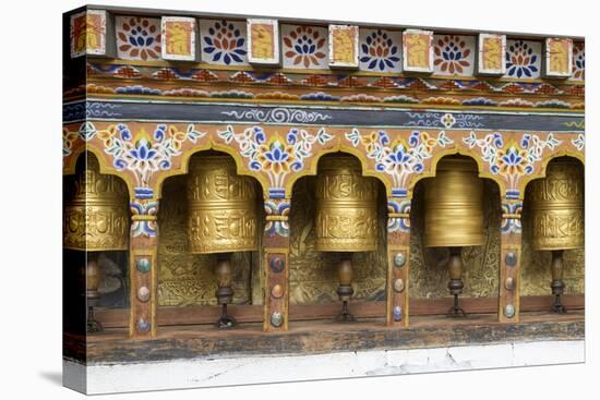 Bhutan. Spinning prayer wheels along a temple wall.-Brenda Tharp-Premier Image Canvas