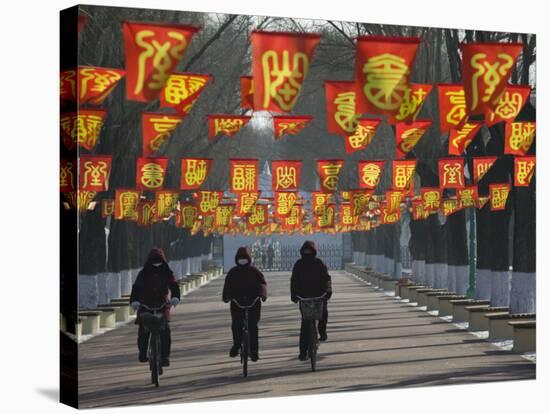 Bicycle Riders at Entranceway to Festival, Ice and Snow Festival, Harbin, Heilongjiang, China-Walter Bibikow-Premier Image Canvas
