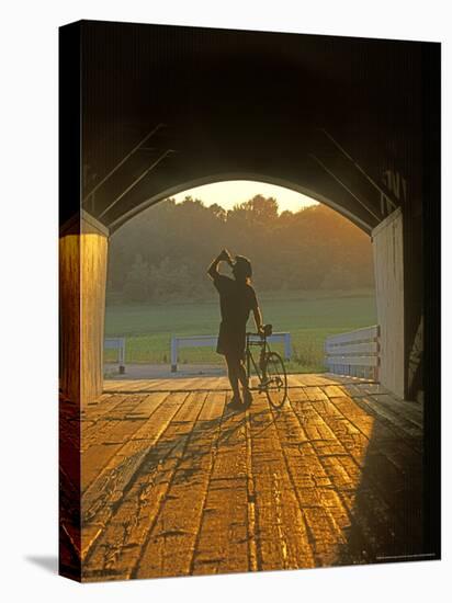 Bicyclist at Covered Bridge, Iowa, USA-Chuck Haney-Premier Image Canvas