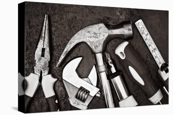 Black and White Image of a Set of Tools on a Textured Metallic Background-Kamira-Premier Image Canvas