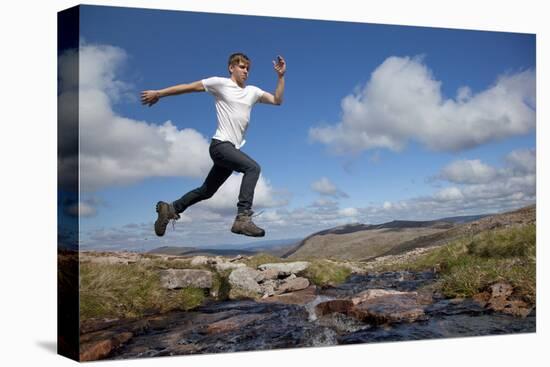 Boy (Aged 17) Jumping across Upland Stream-Mark Hamblin-Premier Image Canvas