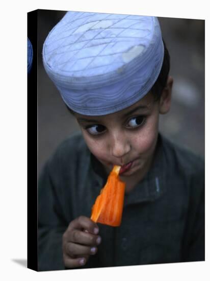 Boy Eats an Ice Lolly in a Neighborhood on the Outskirts of Islamabad, Pakistan-null-Premier Image Canvas