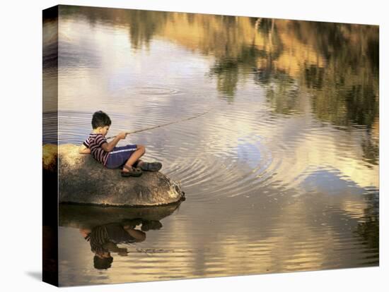 Boy Fishing from a Rock on a Pond-null-Premier Image Canvas