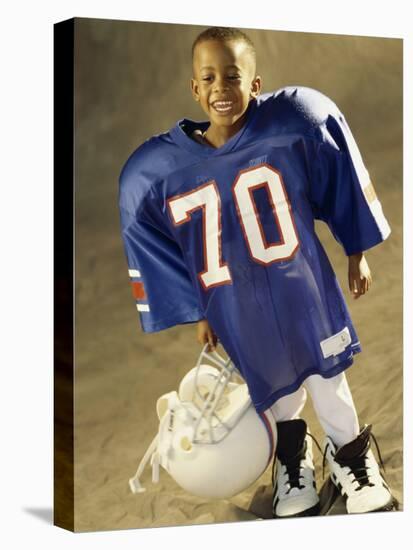 Boy in an Oversized Football Uniform Holding a Helmet-null-Premier Image Canvas