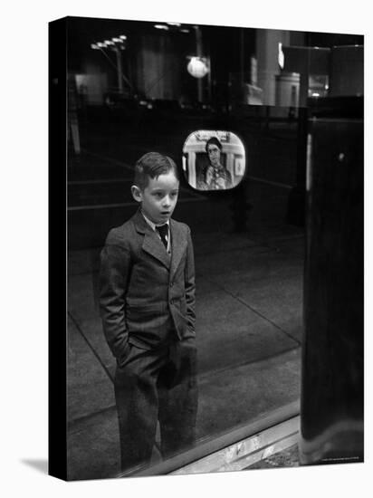 Boy Watching TV on Store Window Set, Glass Reflects the Image Off TV Screen-Ralph Morse-Premier Image Canvas