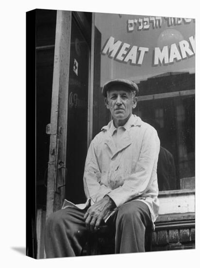 Butcher Taking a Break, Sitting in Front of Meat Market-Ed Clark-Premier Image Canvas