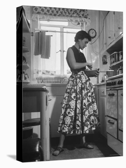 Career Girl Hostedd Joan Wilson in skirt and sleeveless blouse cooking in kitchen-Nina Leen-Premier Image Canvas