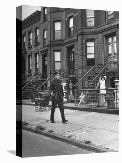 Children Watching a Policeman Walk His Beat in Front of Apartment Buildings-Ed Clark-Premier Image Canvas