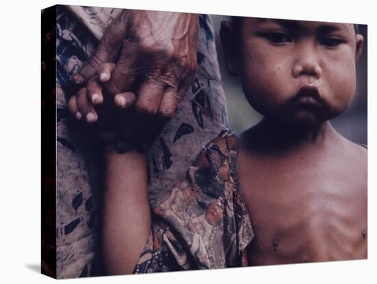 Close-Up of an Indonesian Child Holding on to the Hand of His Mother-Co Rentmeester-Premier Image Canvas