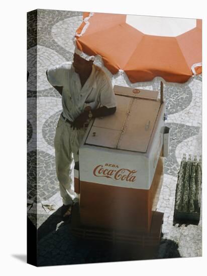 Coca-Cola Vendor Leaning on Cart with Umbrella on Mosaic Sidewalk, Copacabana Beach, Rio de Janeiro-Dmitri Kessel-Premier Image Canvas