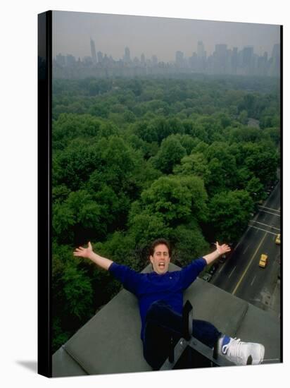 Comedian Jerry Seinfeld Perching Precariously on Roof Ledge Overlooking Central Park-Ted Thai-Premier Image Canvas