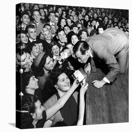 Comedian Milton Berle Trying to Kiss Fans Who Are Asking for Autographs-George Silk-Premier Image Canvas