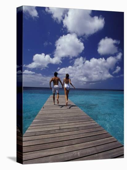 Couple Running on Dock, Curacao, Caribbean-Greg Johnston-Premier Image Canvas