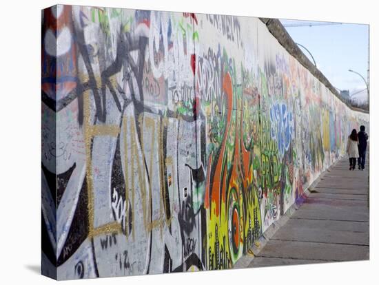 Couple Walking Along the East Side Gallery Berlin Wall Mural, Berlin, Germany, Europe-Simon Montgomery-Premier Image Canvas