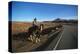 Cowboy on his horse on a highway near Hanksville, Utah, USA-null-Stretched Canvas