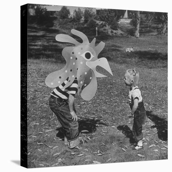 Curious Girl Looking at a Toy Chicken Head Toy by Charles Eames-Allan Grant-Premier Image Canvas