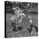 Curious Girl Looking at a Toy Chicken Head Toy by Charles Eames-Allan Grant-Premier Image Canvas