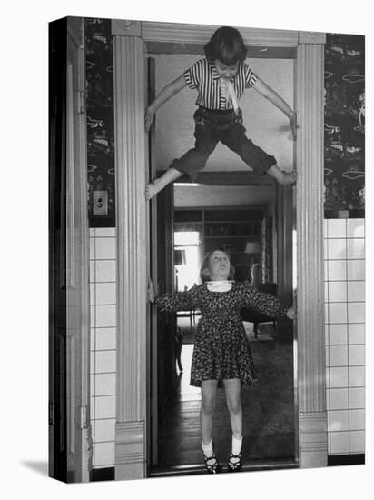 Denise Bruene Climbing Kitchen Door in Bare Feet, Her Hobby, Jan Bruene Says "Don't Fall on Me"-Gordon Parks-Premier Image Canvas