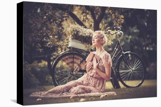 Dreaming Blond Retro Woman with a Book Sitting on a Meadow-NejroN Photo-Premier Image Canvas